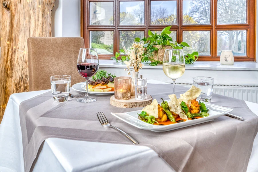 Liebevoll angerichtete Gerichte mit Wein im Restaurant Kuckuck des Hotel Beckmann in Göttingen.