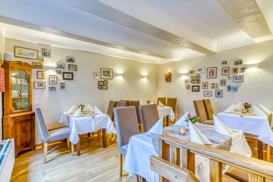 Karl-Beckmann-Stube im Restaurant Kuckuck des Hotel Beckmann Göttingen mit historischen Bildern und gedeckten Tischen.